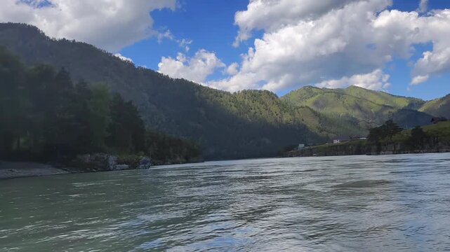 A motorboat ride along mountain river. Slow motion of speedboating on Altai river Katun in rainy day