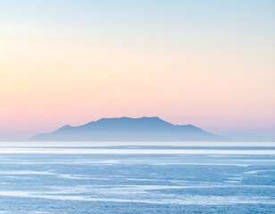 Distant island silhouette in blue waters under a soft, pastel-colored sky at dawn or dusk