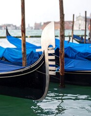 Front view of a gondola with blurred buildings and water in the background on a cloudy day