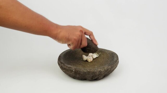 Grinding Garlic Using Traditional Stone Mortar and Pestle