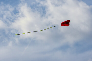 Colorful kites soaring high in the sky at a vibrant kite festival on a sunny day.
