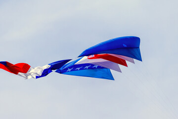Colorful kites soaring high in the sky at a vibrant kite festival on a sunny day.