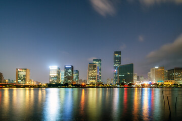 Obraz premium Night View of City Skyline with River Reflections