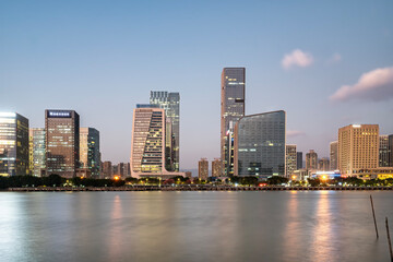 Naklejka premium Modern Skyscrapers by River at Dusk
