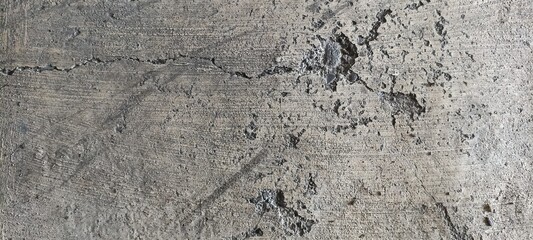 Rough Concrete Wall Texture with Cracks and Pitted Surface. Close-up of rough concrete wall featuring cracks and pitted details, creating a strong industrial abstract texture