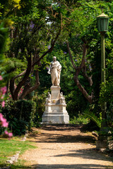 Vertical view of the marble statue of Ioannis Varvakis, a Greek national hero and benefactor, in the lush National Garden of Athens, Greece.