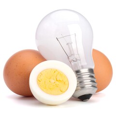 A still life of a lit lightbulb and brown eggs, one halved to reveal the golden yolk. Isolated on white