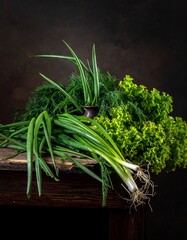 A still-life composition of fresh, green produce arranged on a weathered wooden table against a dark, textured background