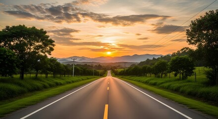 Sunset on a scenic highway with mountains and lush greenery in the background