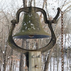 Fototapeta premium Vintage Metal Farm Bell Mounted on Wooden Post in Winter