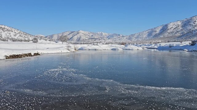 A frozen lake reflects snowy hills and distant mountains under a clear sky, capturing the serene beauty of untouched winter nature.
📍Marivan, Kurdistan 