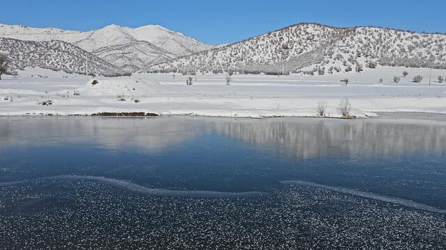 A frozen lake reflects snowy hills and distant mountains under a clear sky, capturing the serene beauty of untouched winter nature.
📍Marivan, Kurdistan 