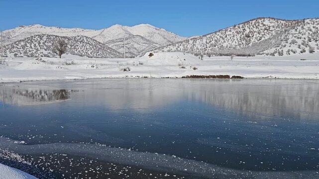 A frozen lake reflects snowy hills and distant mountains under a clear sky, capturing the serene beauty of untouched winter nature.
📍Marivan, Kurdistan 