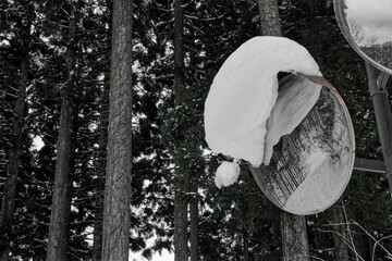 雪が積もったカーブミラー