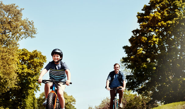 Happy dad, kid and riding with bicycle for bonding, fun childhood or physical activity together. Father, child or cycling with son or smile for travel, learning or health and wellness in neighborhood