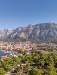 Naklejka premium Croatian view of the Makarska Riviera, Biokovo Mountains, and the coast. Sunny day over the Adriatic Sea, forests, beaches, and town. Drone photos.