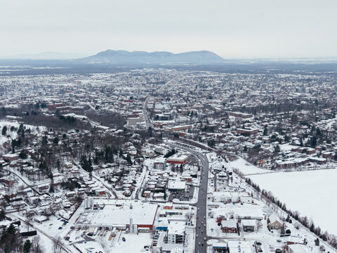 Aerial winter view of Granby city with snowy streets, church buildings and urban landscape, Quebec, Canada. g