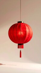 Obraz premium A single vibrant red Chinese lantern illuminated with a soft light, casting a gentle shadow on a plain white background