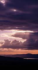 Fototapeta premium Dramatic sunset over mountains and water with cloudy sky