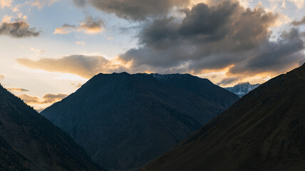 Obraz premium Dramatic Summer sunset clouds in himalayas. Mountain silhouette in golden sunset
