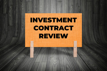 Concept words Investment Contract Review, Light Orange Grunge Texture Rectangle Card Held By...
