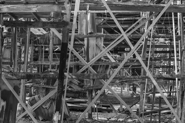 Black and White View of Chaotic Wooden Beams and Corrugated Metal Structure in a Rustic Shipyard Workshop