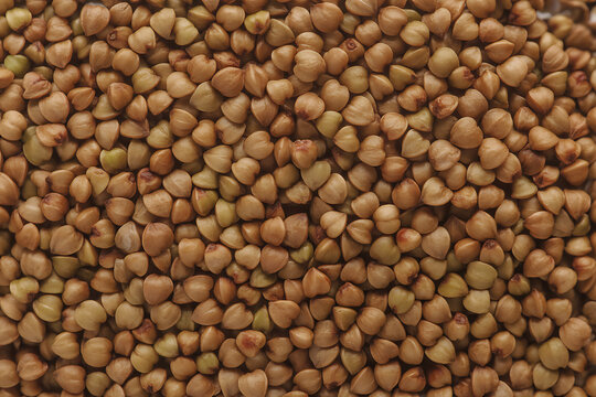 Close-up overhead view of raw, uncooked buckwheat groats, showcasing their natural texture and organic quality for healthy eating.