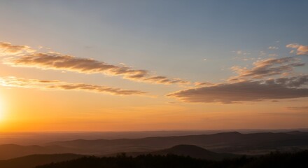 The sun is setting over the mountains in the distance with few.