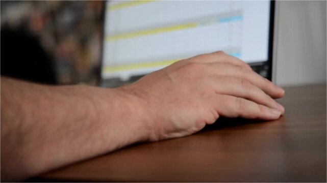Data Analyst Using Laptop Typing and Scrolling Through Data with Blurred Screen