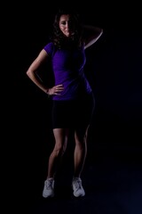 Confident athletic woman, Energetic female trainer displays commanding posture, Sculpted female athlete in bold stance with intense lighting and determined expression