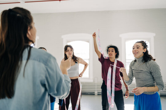 Group of diverse dancers learning rhythmic ribbon movements