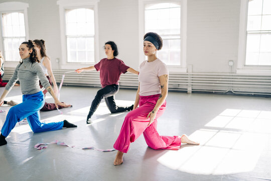 Women rehearsing contemporary dance movement in studio