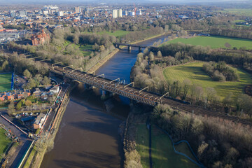 Fototapeta premium Aerial image of the River Ribble featuring the West Coast Main Line viaduct and the green expanse of Avenham Park in Lancashire.