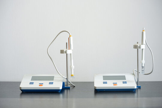 Two laboratory pH meters with electrodes and digital displays on a clean workbench
