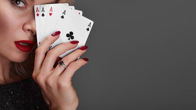 Four Aces Held By Woman Glamorous Closeup Red Lips Red Nails Diamond Ring Sequined Dress Confident Gaze Professional Poker Player Pose High Stakes Poker Vibe Studio Gray Background