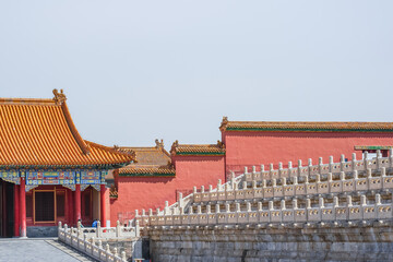 Obraz premium The Forbidden City,Traditional Chinese palace architecture with red walls, golden roof tiles, and stone balustrades under a clear sky