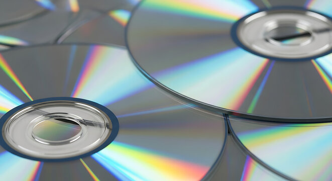 A shimmering close-up view of multiple compact discs reflecting vibrant spectrums of light