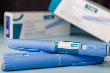 Pharma semaglutide GLP-1 injector pens with boxes on a blue gradient background for metabolic health and weight loss therapy concepts.