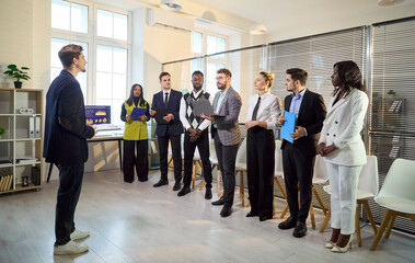 Fototapeta premium Business team meeting with training coach leader. In a modern office, diversity guides a group preparing for seminar and presentation practice. Clear leadership and strong teamwork concept.