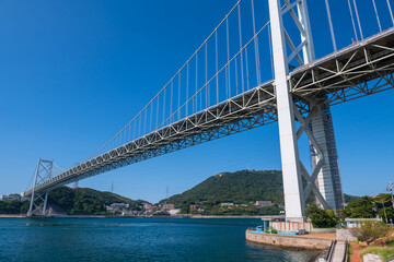 Obraz premium Kanmon Bridge by Kanmon Strait against blue sky, Kitakyushu