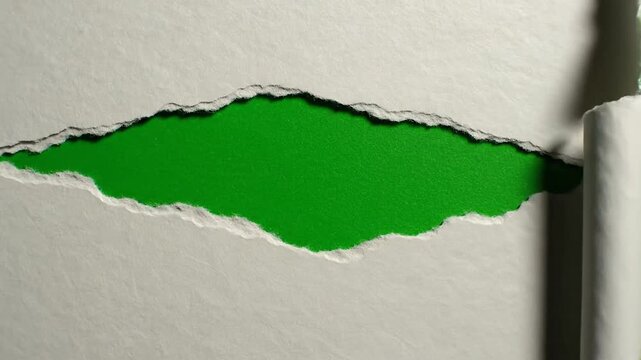 Professional cinematic slow motion stop motion torn paper transition featuring textured cardboard rip effect on chroma key green screen background for video production creative visual layering