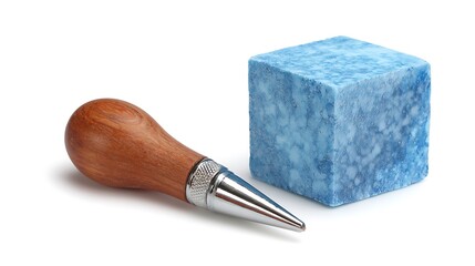 A wooden handled metal stamp next to a blue ink pad on a white background.