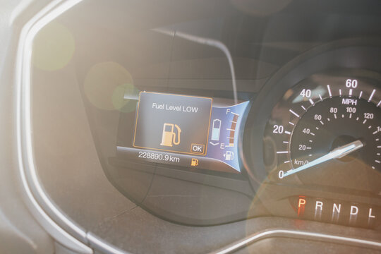 Low fuel alarm notification on car dashboard display. Warning symbol indicating empty tank
