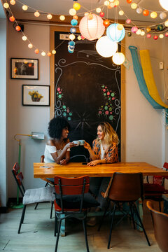 Diverse women friends enjoying coffee meeting at cafe