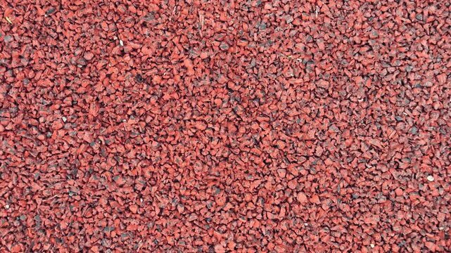 Red Gravel Surface, Compact Stones Create Sturdy Foundation, Earthy Tones With Fine Granules Ensure Durability, Slip resistant Gravel Provides Reliable Footing For Sports Facilities.