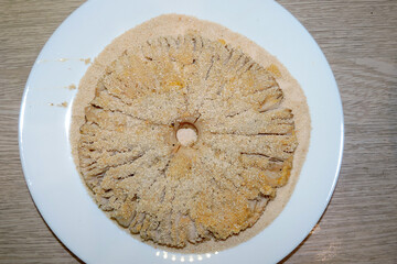 Preparing a parasol mushroom schnitzel: mushroom with breadcrumbs on a plate