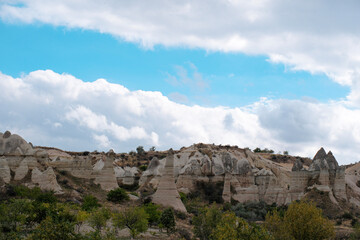 Obraz premium Wide landscape view of Love Valley Trail in Goreme, Cappadocia, Turkey Türkiye, featuring distinctive fairy chimney rock formations under a clear blue