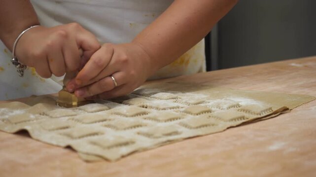 Woman entrepreneur making fresh tortelli pasta in a professional kitchen setting