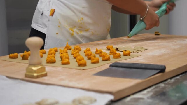 Women entrepreneurs meticulously craft fresh tortelli in a professional kitchen setting