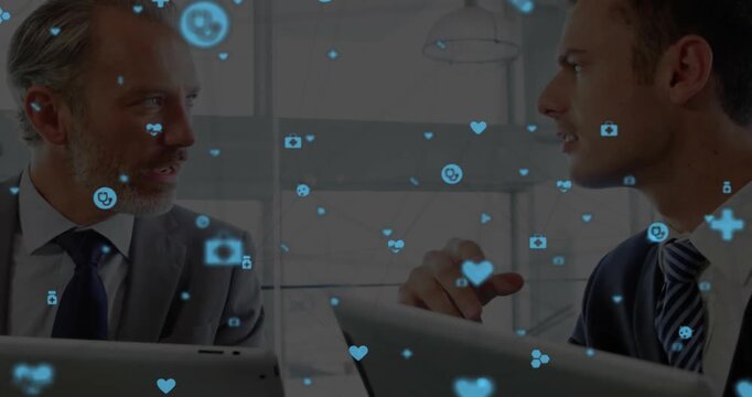 Animation of network of connections with icons over diverse business people in office